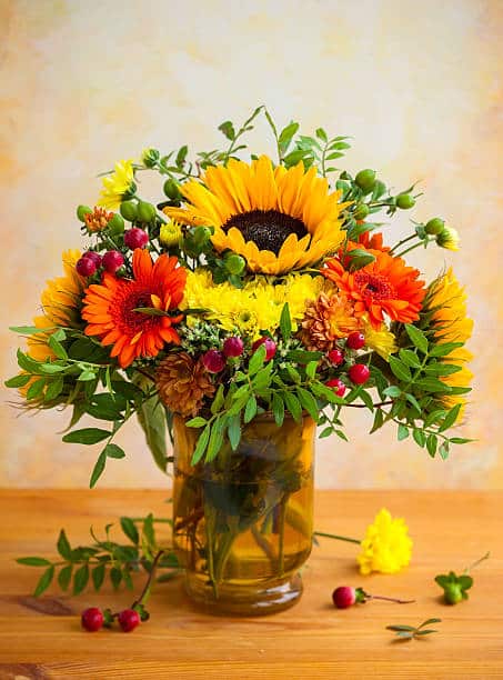 autumnal flowers and berries in a vase